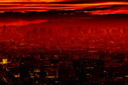 The featured image captures the skyline of Osaka bathed in a stunning red sunset. The fiery hues of the sky contrast sharply with the dark silhouettes of the city, creating a dramatic and captivating scene.