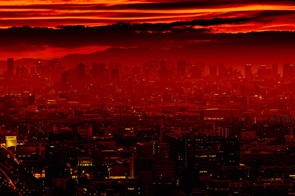 The featured image captures the skyline of Osaka bathed in a stunning red sunset. The fiery hues of the sky contrast sharply with the dark silhouettes of the city, creating a dramatic and captivating scene.
