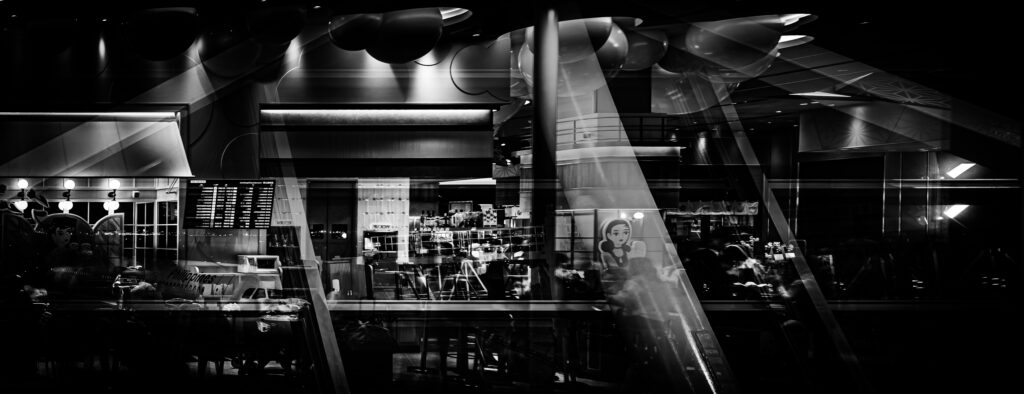 The featured image captures the international departure lobby at Kansai International Airport at night. Reflections in the windows show the airport's interior, while the distant lights of Osaka can be seen through the glass.