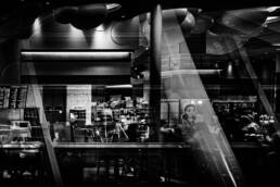 The featured image captures the international departure lobby at Kansai International Airport at night. Reflections in the windows show the airport's interior, while the distant lights of Osaka can be seen through the glass.