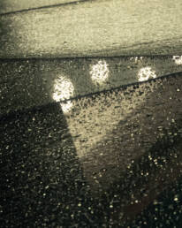 Image of rain-covered glass roof with a geometric design reflecting ambient lights, creating a moody and atmospheric urban scene. perfect for themes related to architecture, weather, and urban photography.