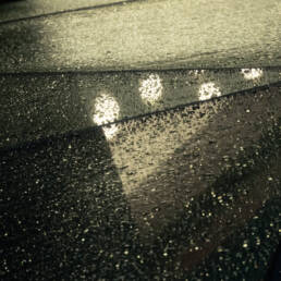 Image of rain-covered glass roof with a geometric design reflecting ambient lights, creating a moody and atmospheric urban scene. perfect for themes related to architecture, weather, and urban photography.