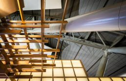 Image of this image captures a modern architectural ceiling structure at kansai international airport, osaka. it features a striking design with interwoven wooden beams against a backdrop of sleek metal roofing and geometric patterns. ideal for architectural inspiration and design concepts. keywords: kansai international