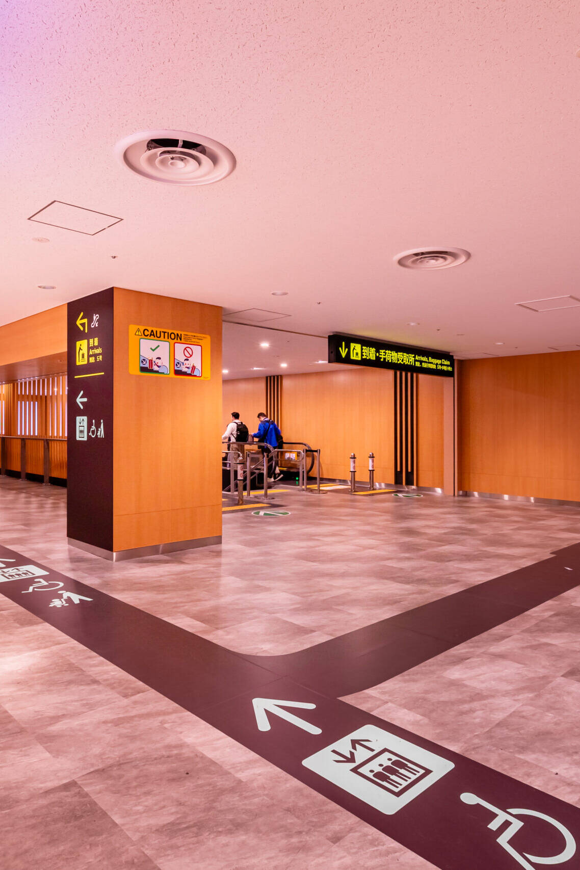 Image of modern airport corridor with clear directional signage and elevator access, featuring spacious layout and polished flooring. provides easy navigation for travelers, including accessibility options. ideal for safe, efficient transit in busy airport environments.