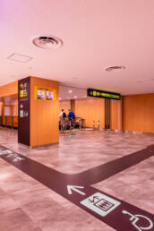 Image of modern airport corridor with clear directional signage and elevator access, featuring spacious layout and polished flooring. provides easy navigation for travelers, including accessibility options. ideal for safe, efficient transit in busy airport environments.
