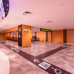 Image of modern airport corridor with clear directional signage and elevator access, featuring spacious layout and polished flooring. provides easy navigation for travelers, including accessibility options. ideal for safe, efficient transit in busy airport environments.