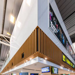 Image of the image depicts a modern airport interior, showcasing a clean, futuristic design with a prominent arrival sign in japanese. the architecture features sleek wooden paneling, digital displays, and bright lighting, emphasizing a busy, international environment. ideal for keywords like 